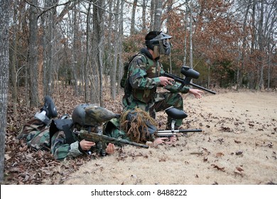 Three Kids Outside Playing Paintball In Winter.