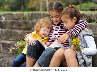 Three Kids Reading A Book