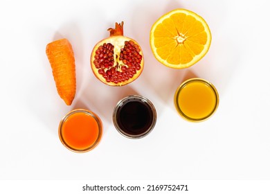 three kinds of juices orange, pomegranate, carrot on a white surface, carrot and orange slices, pomegranate seeds, top view, healthy food concept, vitamin detox, diet - Powered by Shutterstock