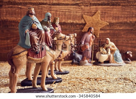 the three kings on their camels and the holy family in a rustic nativity scene