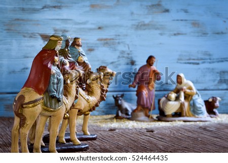 the three kings on their camels and the holy family in a rustic nativity scene