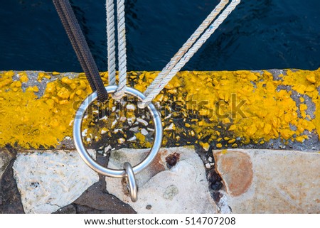 three knots attaching to one ring anchored on canal bank
