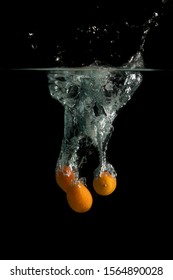 Three Kumquat Falls Under Water With Splash