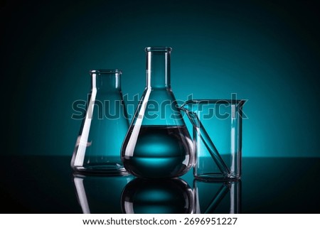 Three laboratory flasks, one partially filled with liquid, on a dark surface.