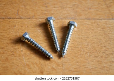 Three Lag Bolts Screws On A Wooden Table