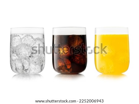 Three large glasses with cola soft drink with orange soda and lemonade.