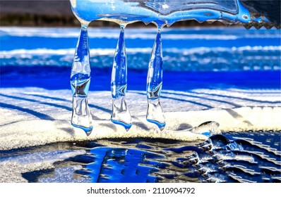 Three large icicles in the sunlight. Icicles melt away. Icicles on sunlight. Three icicles melt away