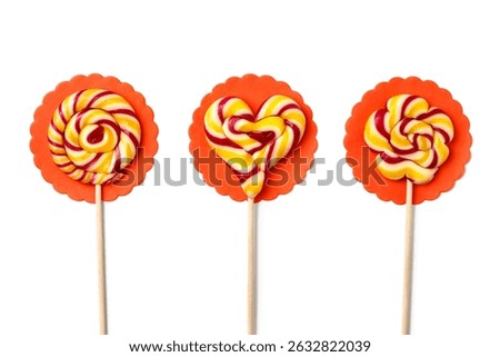 Three large lollipops on a stick in the shape of a circle, a flower and a heart on white background, handmade. Flat lay, Top view.