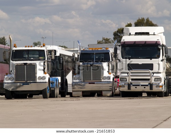 Three large powerful trucks\
parked