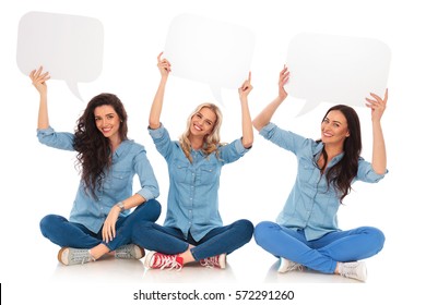 Three Laughing Young Women Holding Speech Bubbles And Sit On White Background