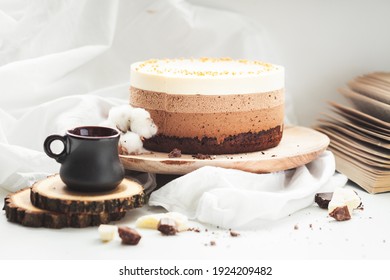 Three Layered Chocolate Mousse Cake On The Wooden Stand On White Background. Good Morning With Fresh Coffee And Chocolate Souffle Cake. Vintage Background