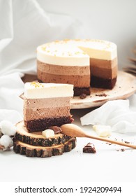 Three Layered Chocolate Mousse Cake On The Wooden Stand On White Background. Good Morning With Fresh Coffee And Chocolate Souffle Cake. Vintage Background