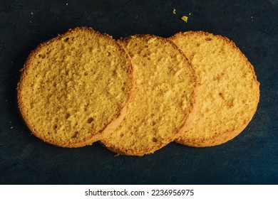 Three layers of a traditional sponge cake side by side on a dark kitchen counter. Top view. DIY, sequence, step by step, part of series. - Powered by Shutterstock