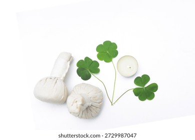 ,three leaf clover with spa herbal balls,with candle,
on white background 
