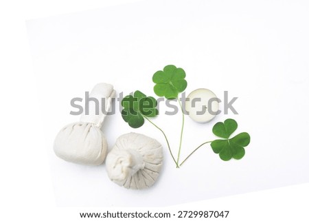,three leaf clover with spa herbal balls,with candle,
on white background 
