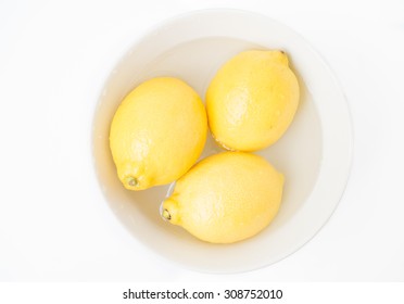 Three Lemons In A White Bowl