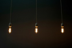 Three Light Bulbs Light Bulbs Dimly Glow In The Dark
Dim Lighting Of The Space
Dark Background, Barely Lit By Three Lamps