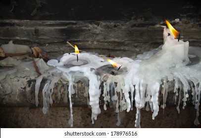 Three Lit Candles Burning And Melting.