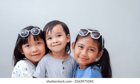 three little asian child, fashion and friendship concept - happy children in casual clothes and sunglasses over light color background - Powered by Shutterstock