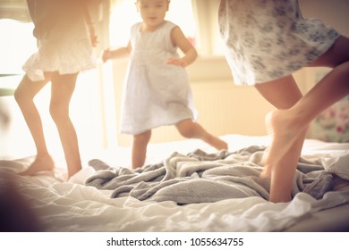 Three little girls dancing in bed. Space for copy. - Powered by Shutterstock