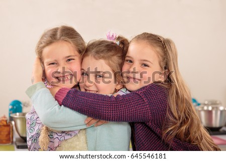 Three little girls embrace