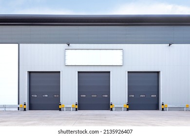 Three loading doors of an industrial warehouse - Shutterstock ID 2135926407