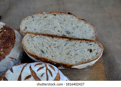 Three Loafs Of Home Baked Wheat Bread;  Crusty Banana Bread On Wooden Board With Bred Texture Of Loaf Cut In Half