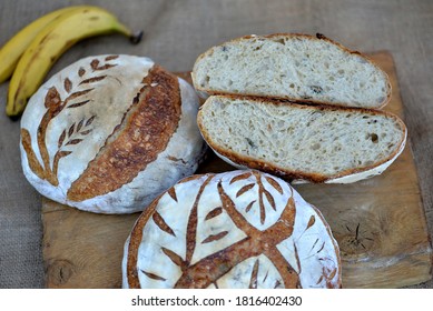 Three Loafs Of Home Baked Wheat Bread;  Crusty Banana Bread On Wooden Board With Bred Texture Of Loaf Cut In Half