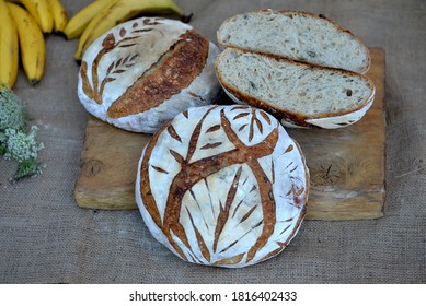 Three Loafs Of Home Baked Wheat Bread;  Crusty Banana Bread On Wooden Board With Bred Texture Of Loaf Cut In Half