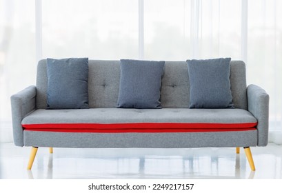 Three luxurious pillows neatly arranged on unoccupied gorgeous deluxe couch near bright curtains in clean living room of apartment. Long modern sofa as interior furniture for comfortable resting. - Shutterstock ID 2249217157