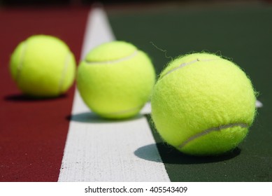 Three Macro Tennis Balls On The Baseline