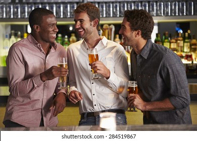 Three Male Friends Enjoying Drink At Bar