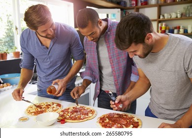 Three Male Friends Making Pizza In Kitchen Together - Powered by Shutterstock