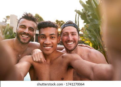 Three Male Friends At Summer Pool Party Taking Selfie On Mobile Phone