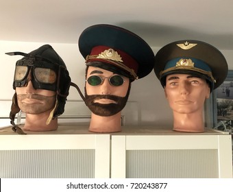 Three Mannequin Heads Dressed As A World War One Aviator And Two Russian Officers From The Communist Era.  The Hammer And Sickle Emblem Is A Communist Symbol From The Russian Revolution, Not A Logo. 