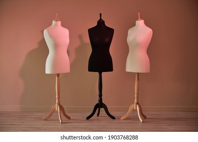 Three mannequins without clothes near the wall