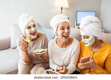 Three Mature Happy Women With Face Masks At Home. Friendship And Wellbeing Concept. Pretty Mature Female Friends Having Spa Day. Natural Homemade Facial Mask. 