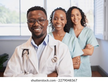 Three medical healthcare professionals stand in a row smiling arms folded - Powered by Shutterstock