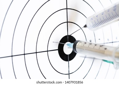 Three medical syringe hit the center of the rifle target. Humor concept of therapy.