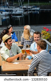 Three Men Drinking Beer At Terrace Bar Enjoying Night Out