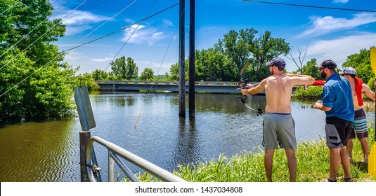 Three Men Fishing With Bow And Arrow In Missouri; Blue Sky In Background