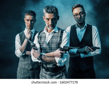 
three men with guns shooting in the studio