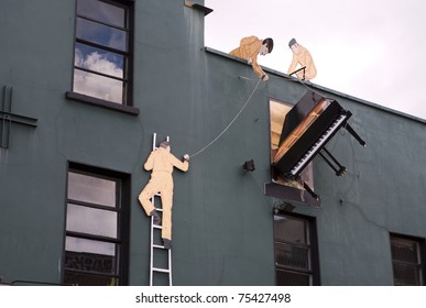 Three Men Moving A Piano