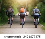 Three men out on a mountain bike and riding on a path