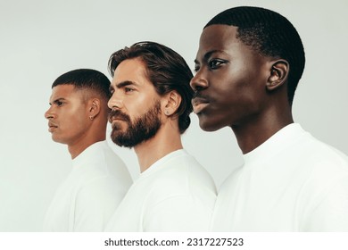 Three men with radiant and flawless skin standing side by side in a studio, looking confident in their healthy and glowing complexions. Diverse young men committing to a consistent skincare routine. - Shutterstock ID 2317227523