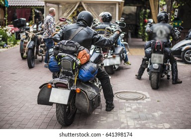 Three Men Sitting On Chopper Motorcycles. Rear Part Of Motorcycle. Black Leather Big Bag. Long Hard Travel. Tourism On Heavy Bikes. 