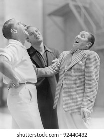 Three Men Standing Together And Laughing