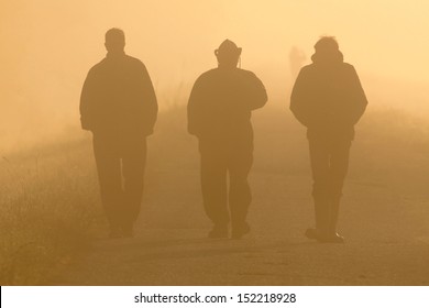 Three Men Walking On Foggy Morning