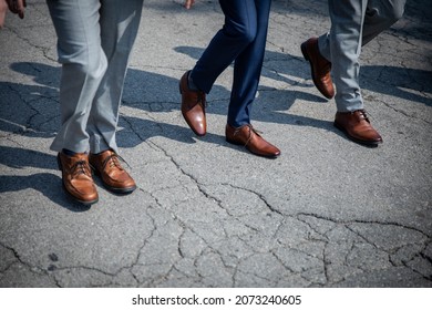 Three men walking together with dress pants and brown designer dress shoes