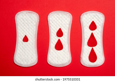 Three menstrual panty liners with drops, isolated on blues background. 